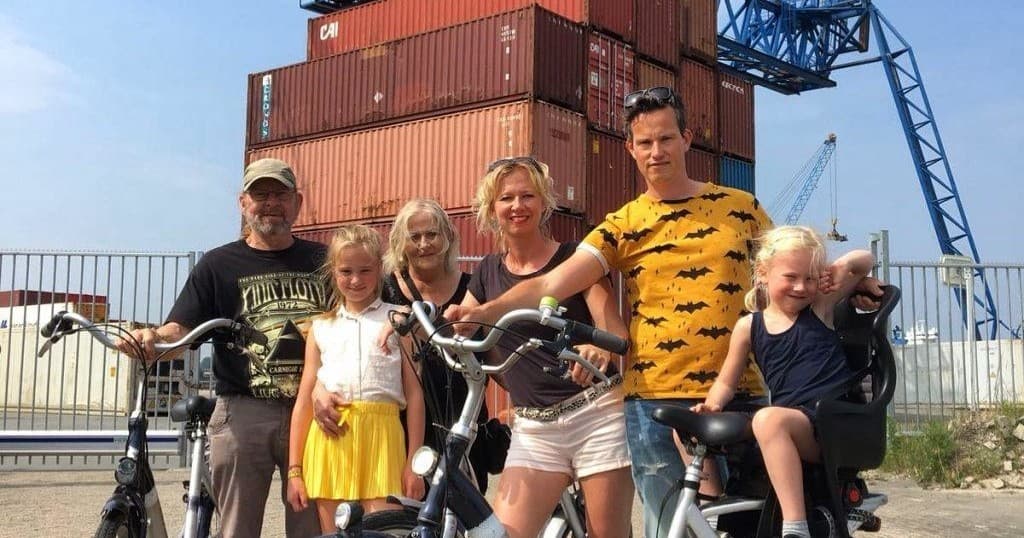 Family with bikes at Rotterdam harbor near shipping containers on tour