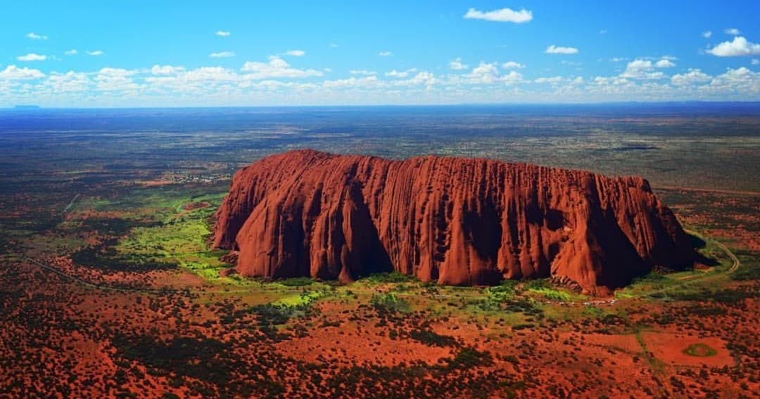 Aerial scenic flight over Uluru red rock and desert plains