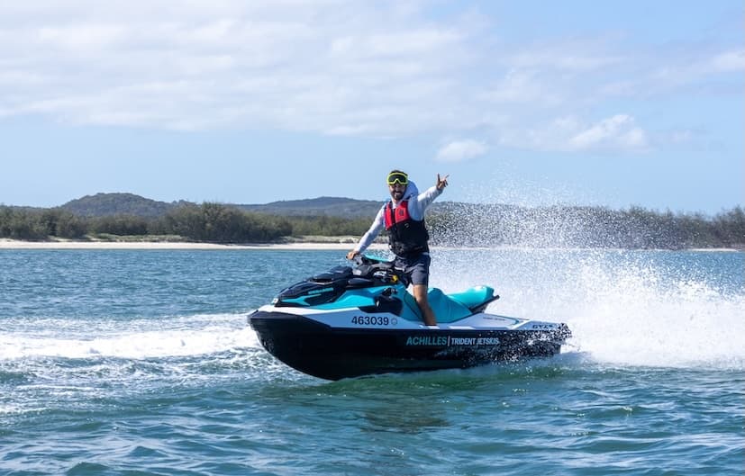Jet ski rider cutting through coastal waves on open ocean