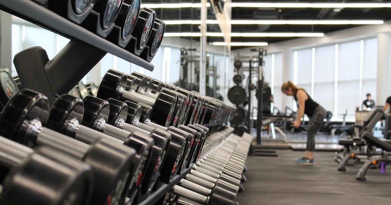 Guest exercising with dumbbells in hotel fitness center interior