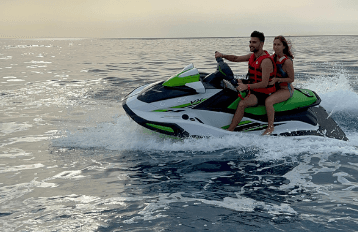 Couple riding jet ski on open ocean at sunset off Fuerteventura
