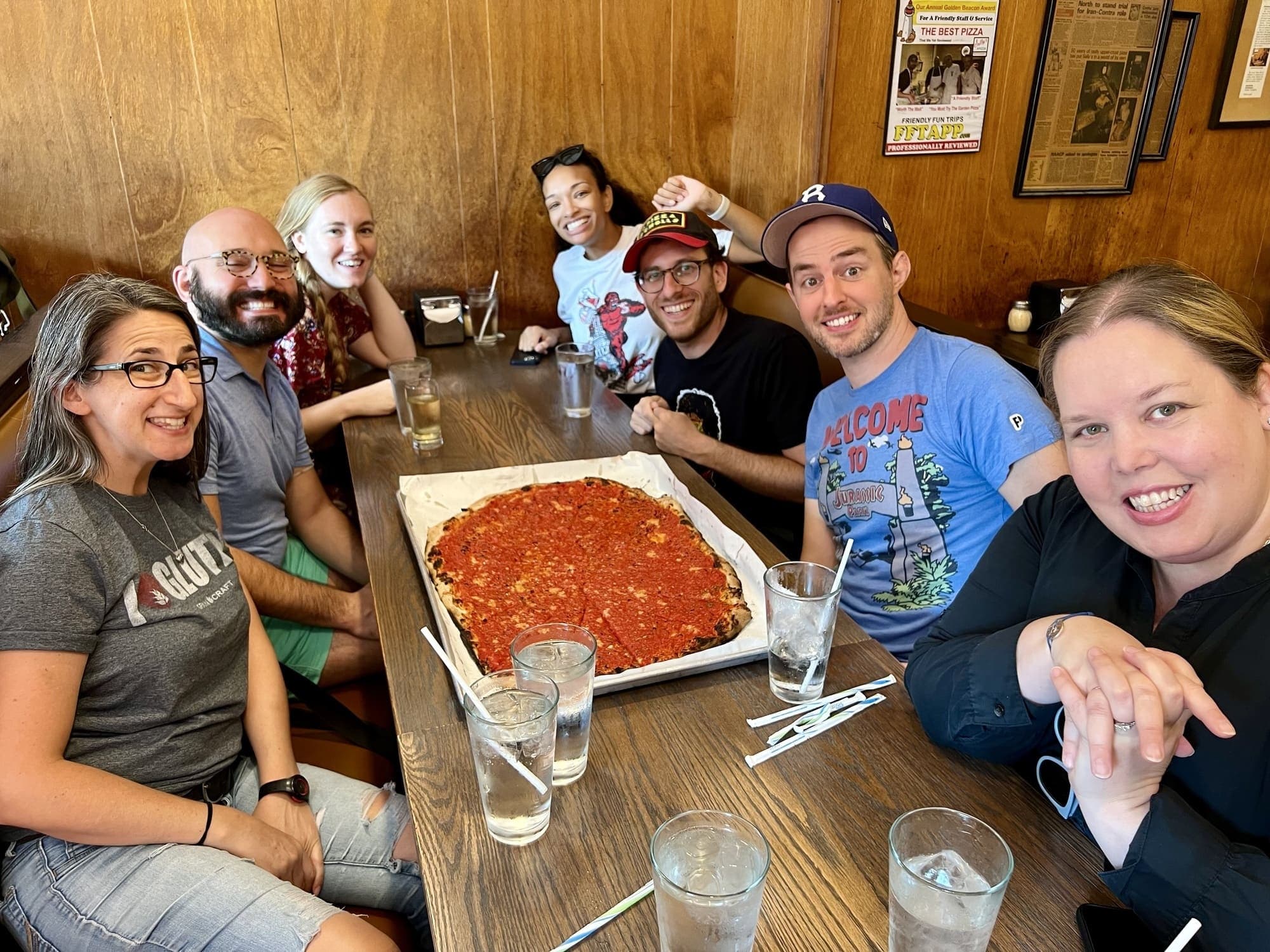 Group gathered around deep-dish pizza inside cozy pizzeria