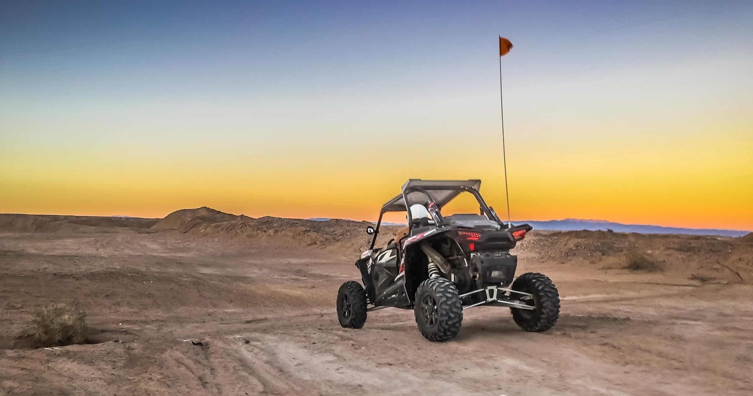 UTV riding at sunset across desert dunes in Palm Springs area