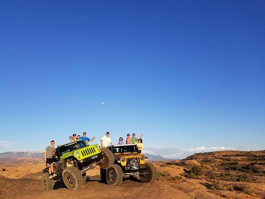 Group Jeep off-road tour on red rock trails under clear sky