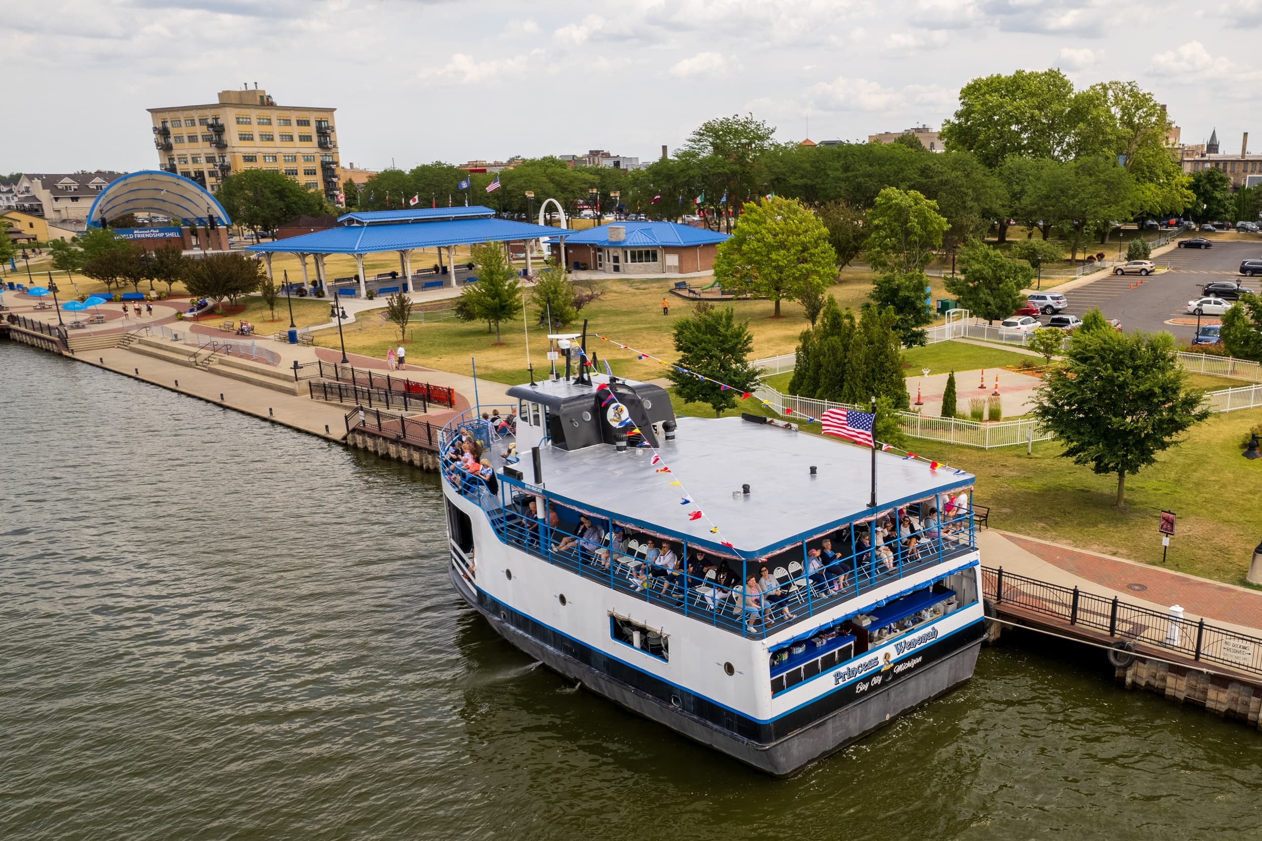 Aerial view of sightseeing boat docking at riverfront pier