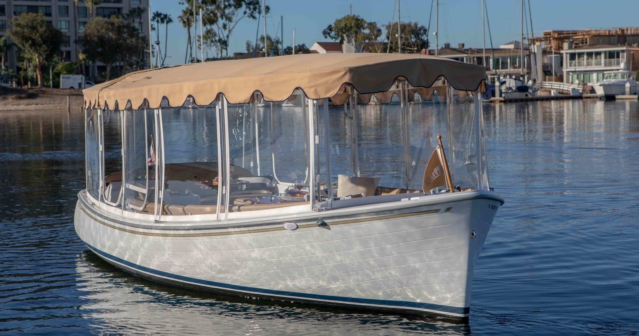Classic covered tour boat gliding on calm marina waters