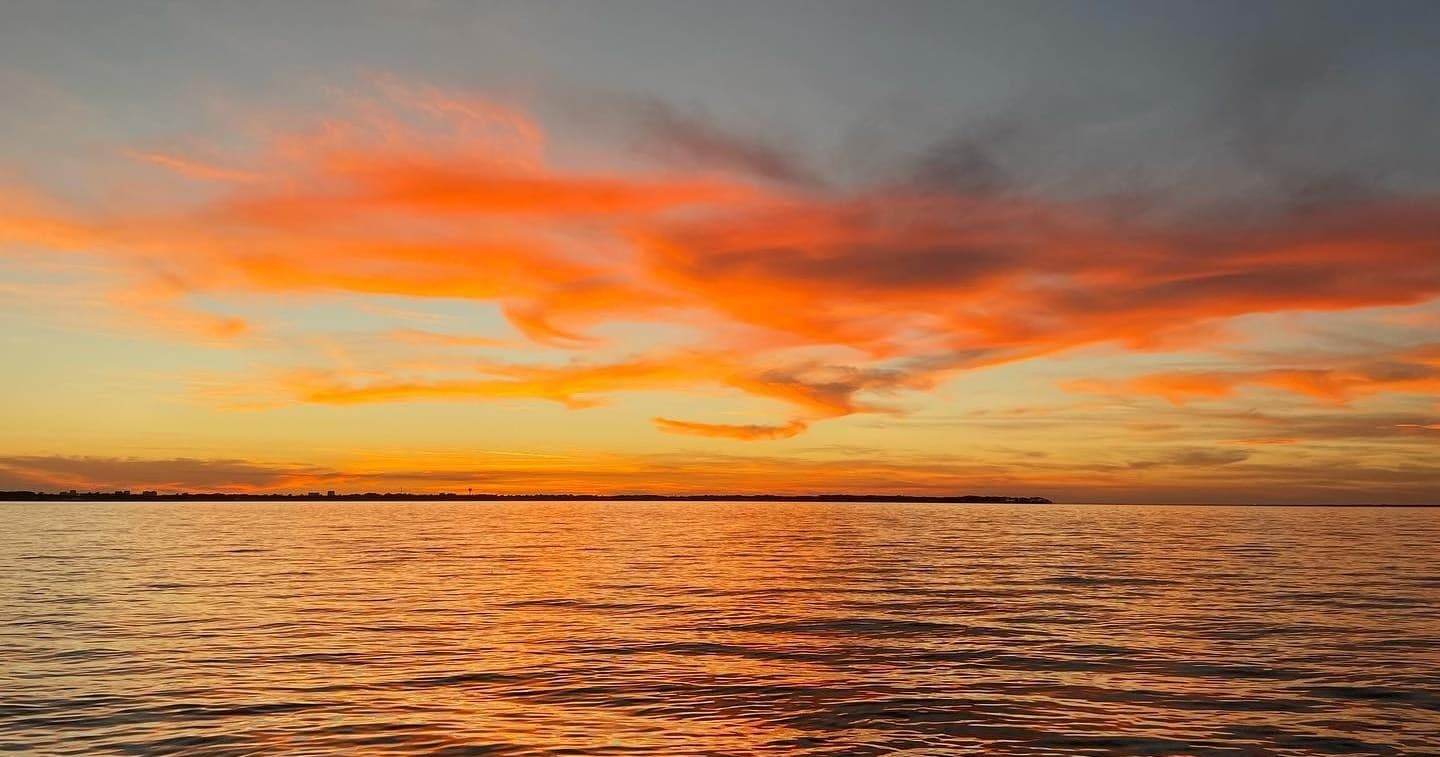 Sunset over calm Gulf waters for scenic boat tours