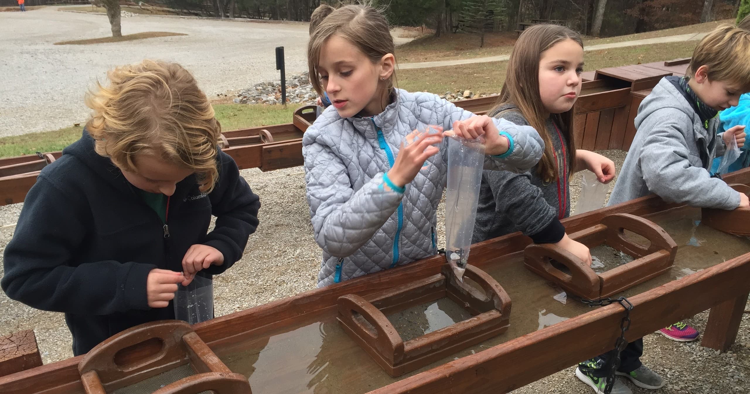 Kids sluice mining for gems at outdoor cave park activity