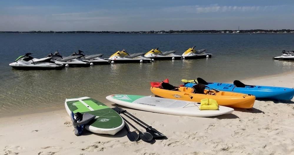Beach gear: paddleboards and kayaks on sandy shore