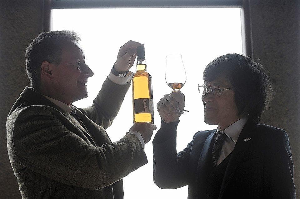Distillery tasting: two people comparing whisky by window light