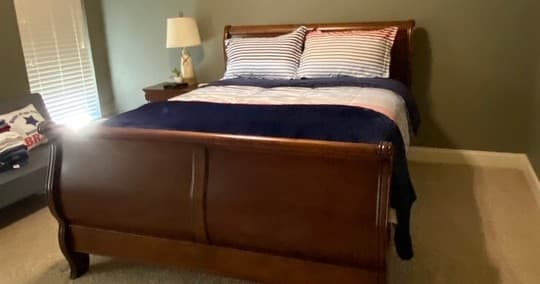 Master bedroom with sleigh bed and coastal-themed bedding