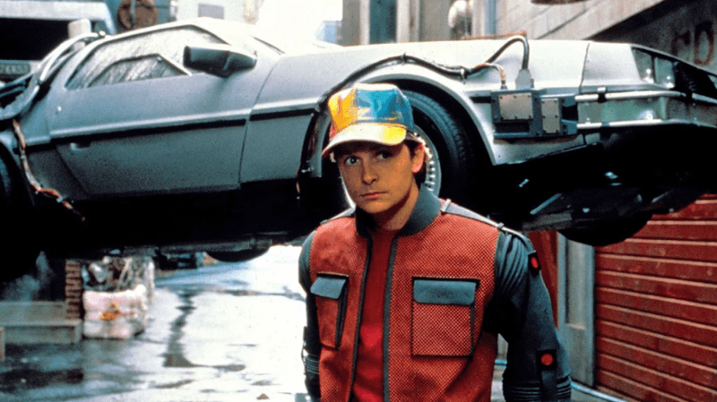 Person in retro jacket near vintage time-travel car in alley
