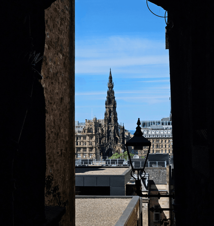 Edinburgh skyline viewed through narrow alleyway with lamppost