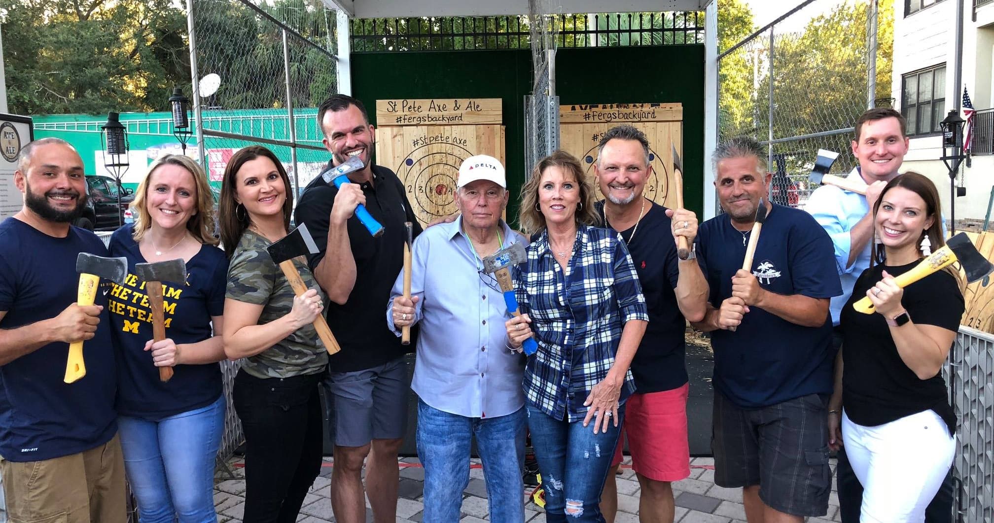 Friends posing with axes at St. Pete outdoor axe throwing venue