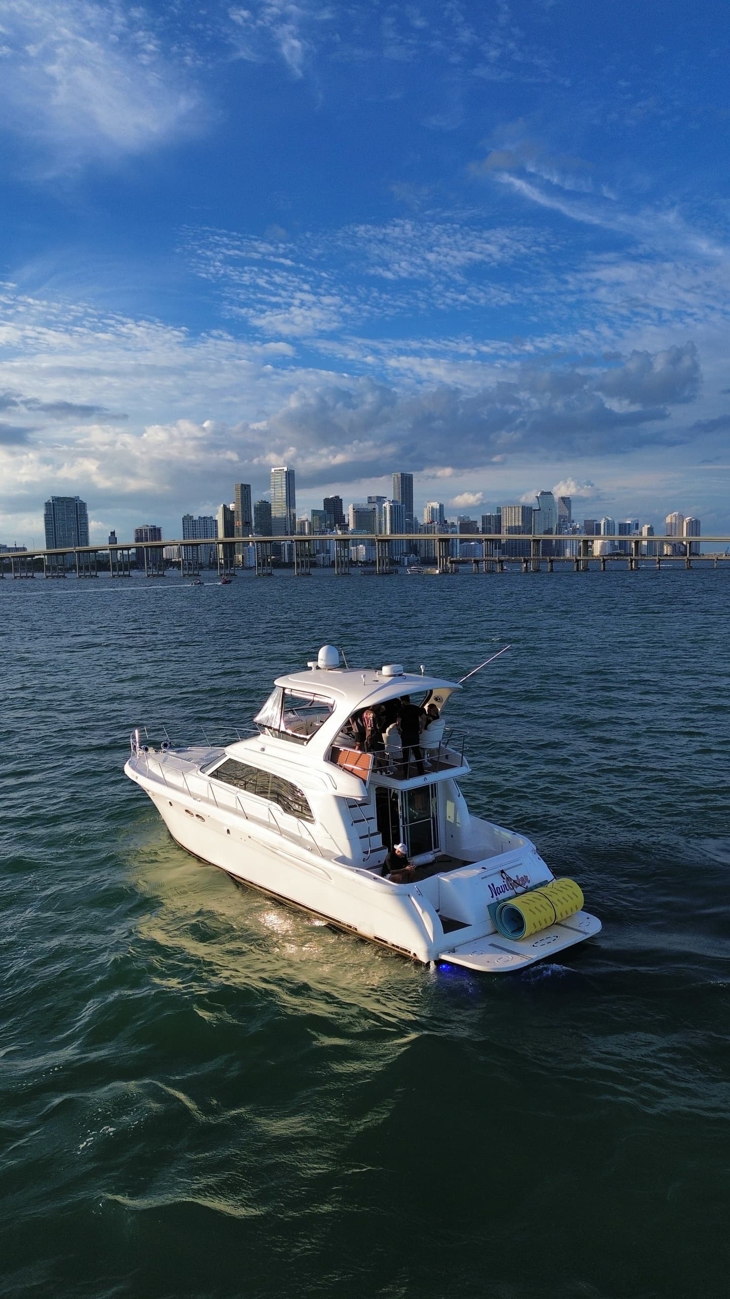 Motorboat cruising near city skyline on calm blue waters