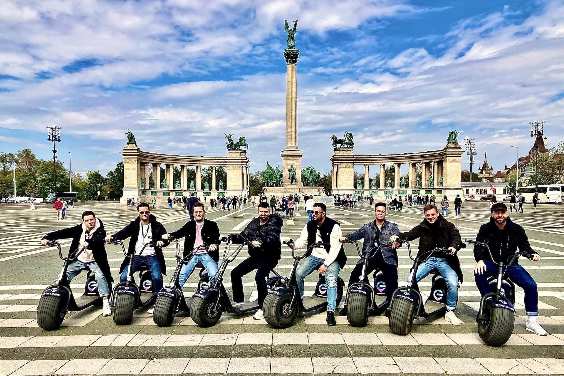 Electric scooter tour group posing at Heroes' Square in Budapest