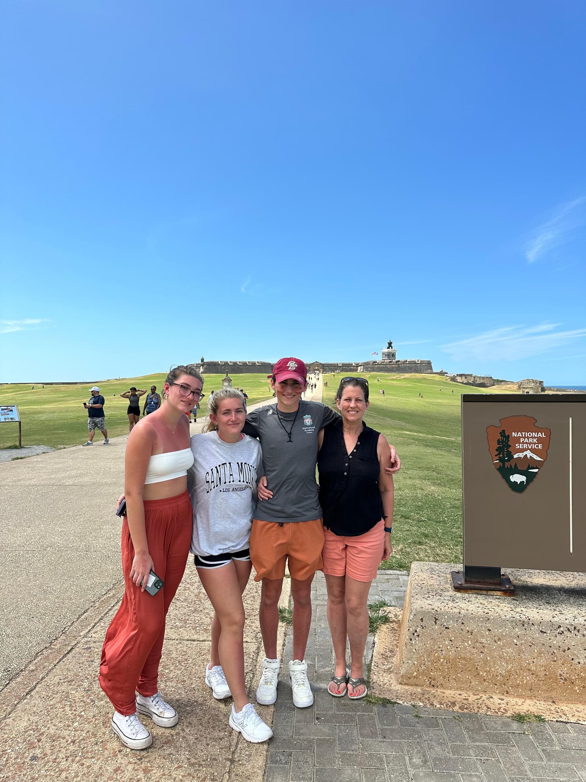Friends at coastal overlook with lighthouse view, sunny day