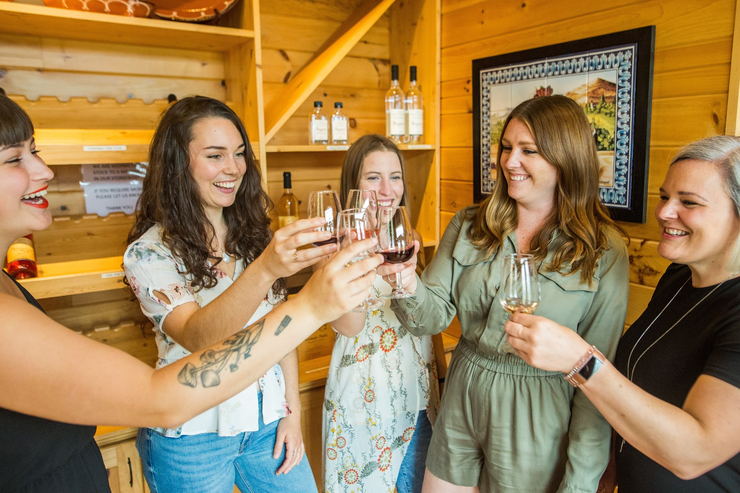 Friends clinking glasses at a rustic tasting room, celebratory toast