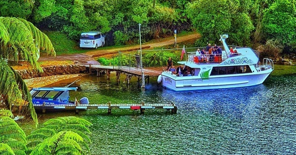 Colorful tour boats docked at sheltered bay, scenic lake access