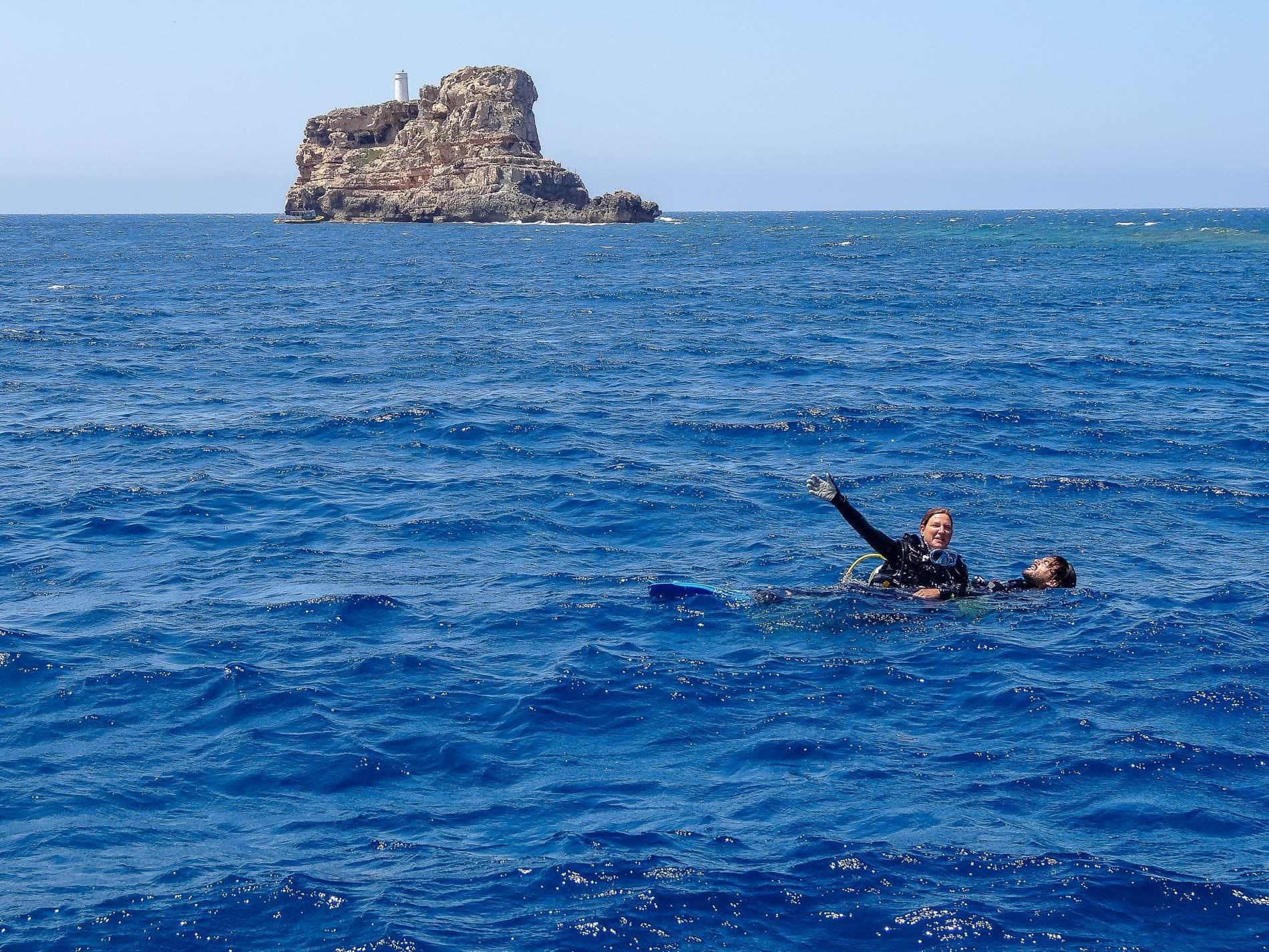 Snorkeler floating near rocky islet in open sea