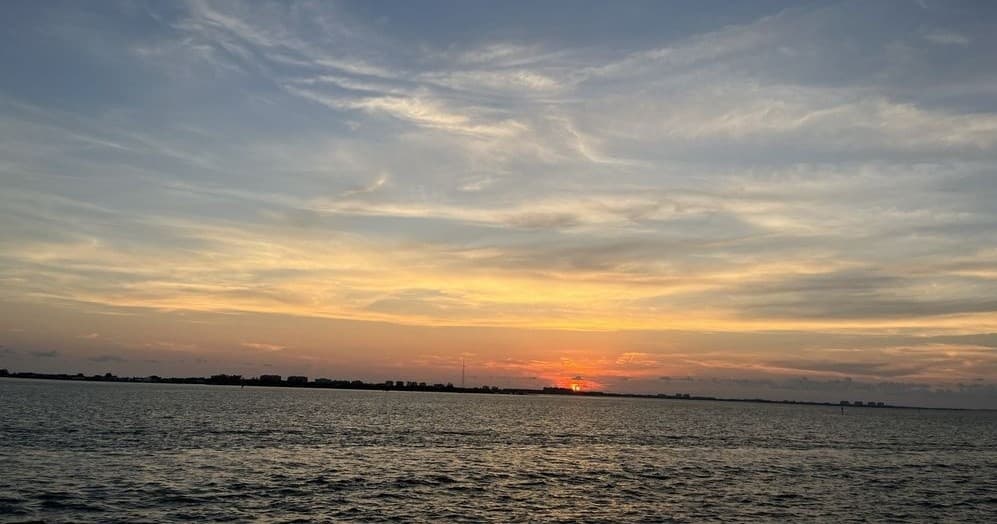 Calm sunset over open water, panoramic bay cruise view