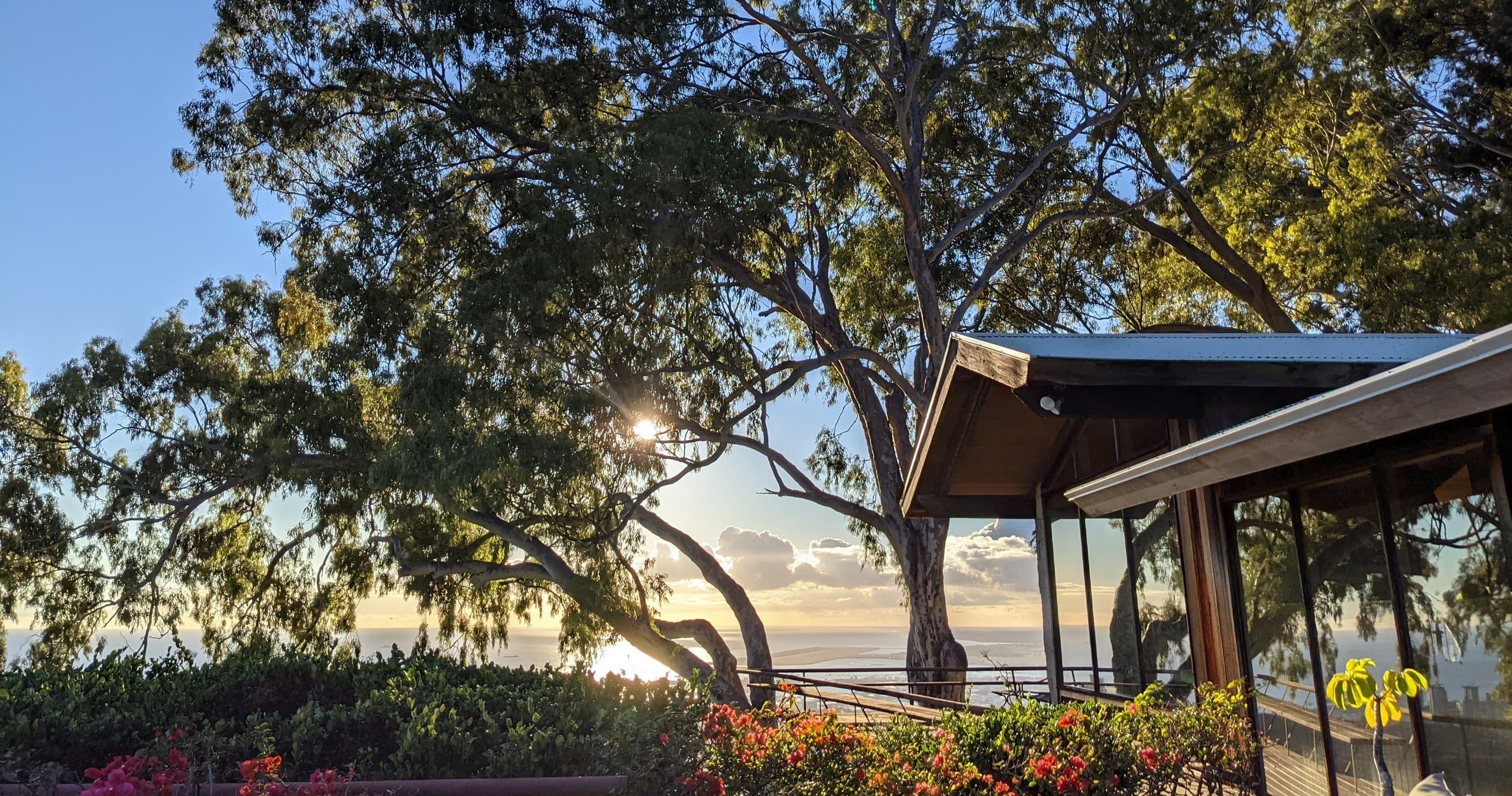 Coastal sunrise view from cliffside house overlooking ocean
