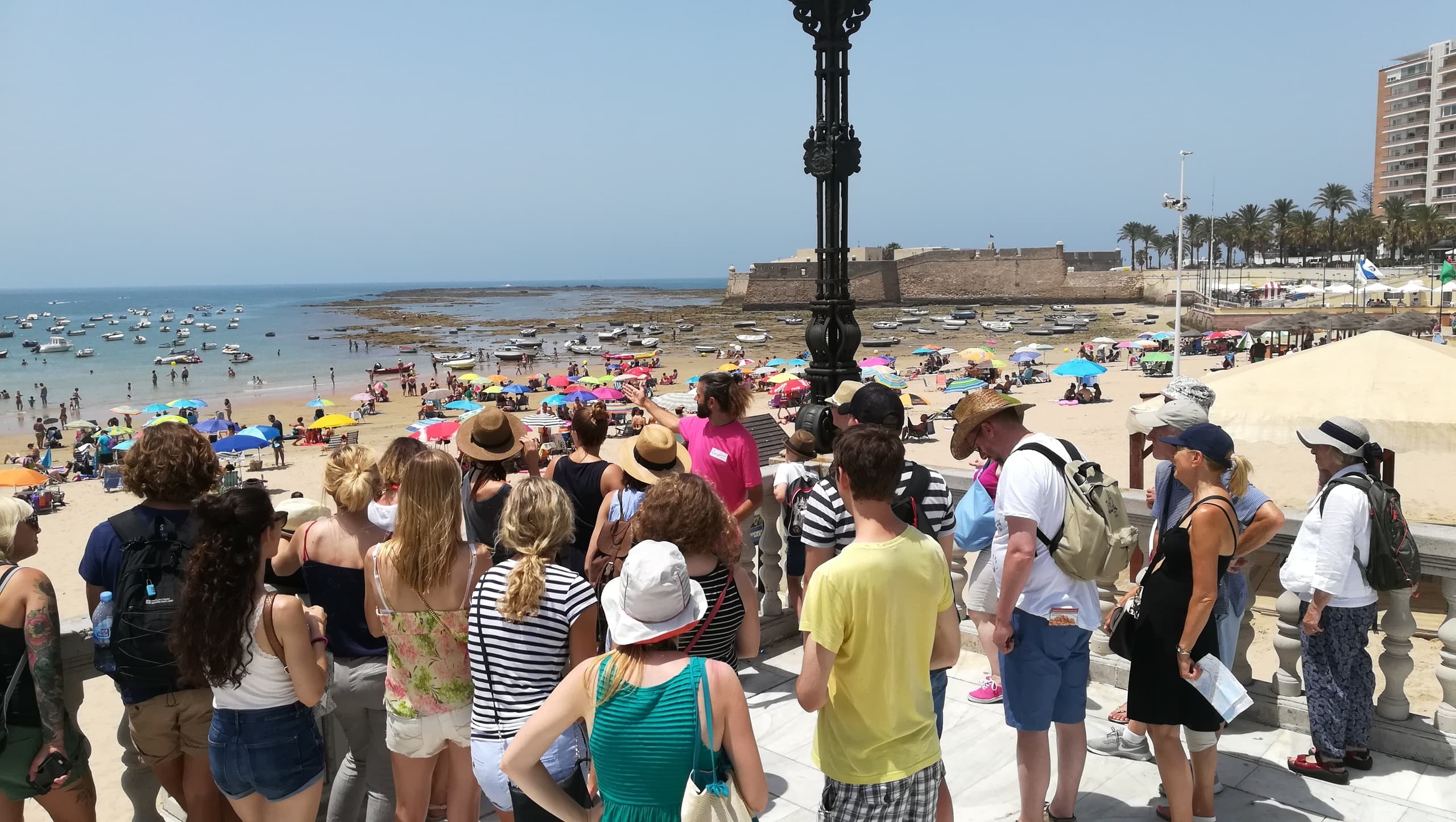 Beachfront crowd at Cádiz coastline enjoying seaside walking tour