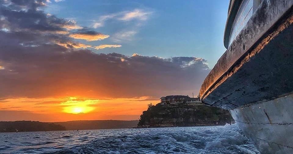 Sunset ferry ride past coastal cliffs near Sydney harbor