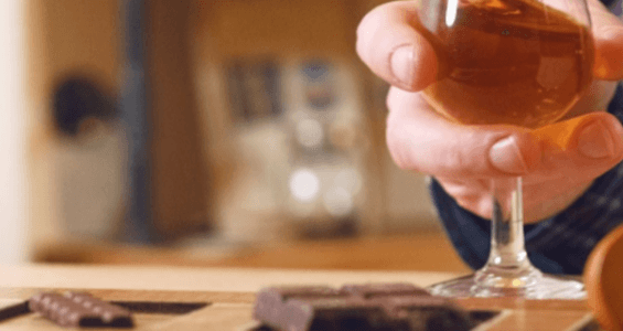 Chocolate and whisky tasting in chocolatarium, hand holding glass