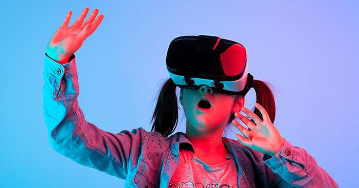 Girl with VR headset in neon studio, surprised and immersed