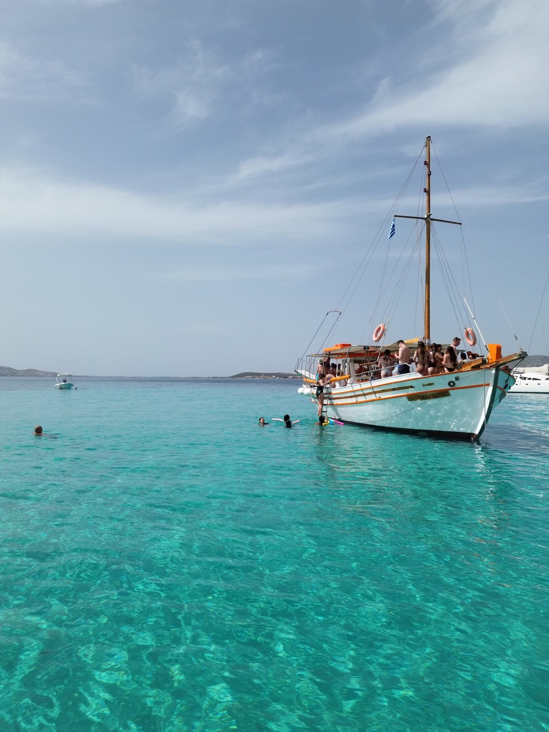Sailing day trip with anchored wooden boat in shallow turquoise water