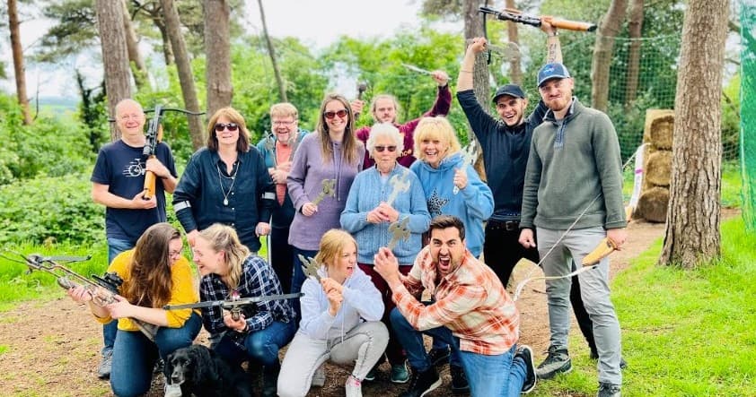 Large outdoor group posing at forest adventure site