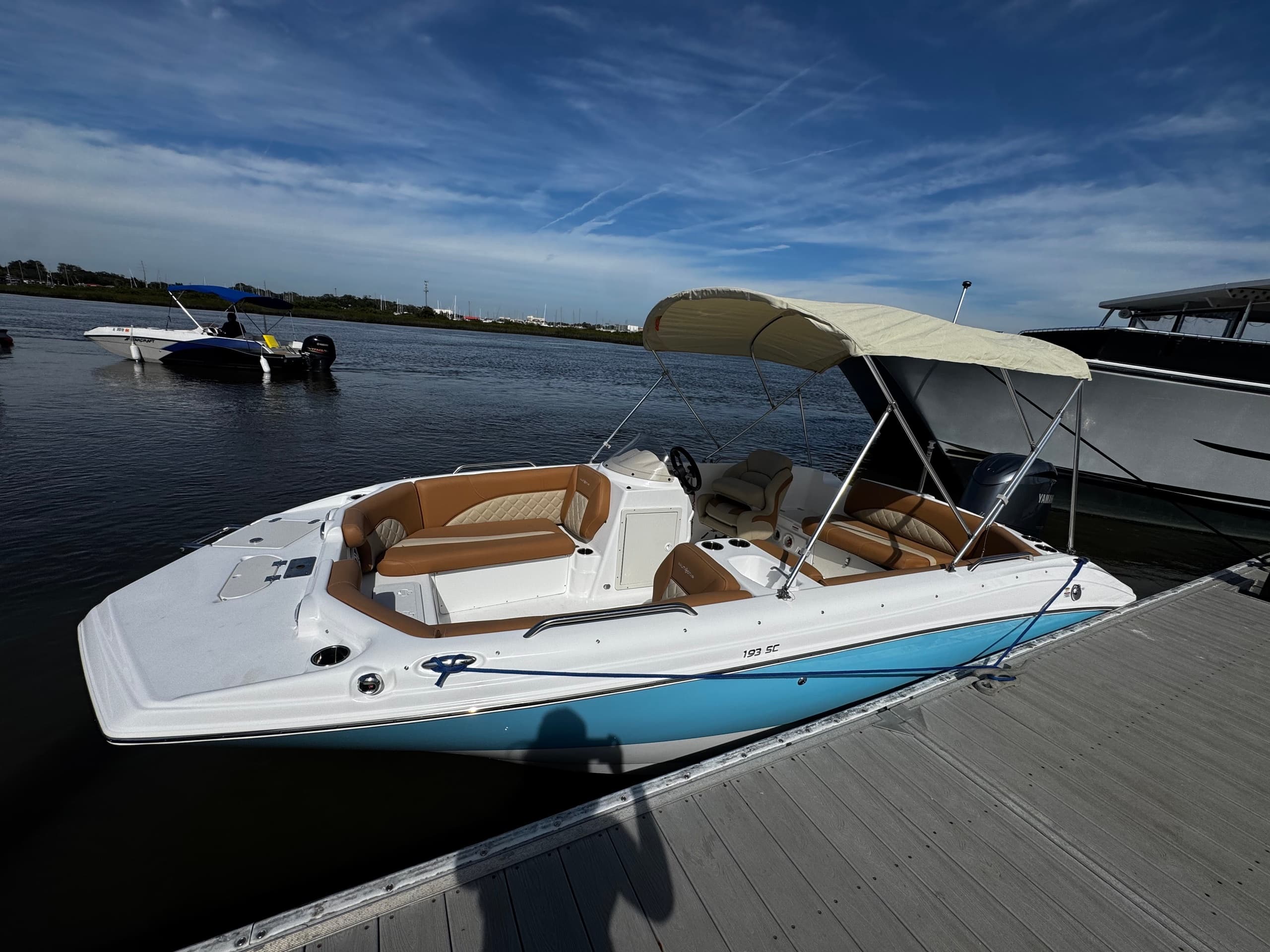 Speedboat moored at marina with open sky, dockside coastal view