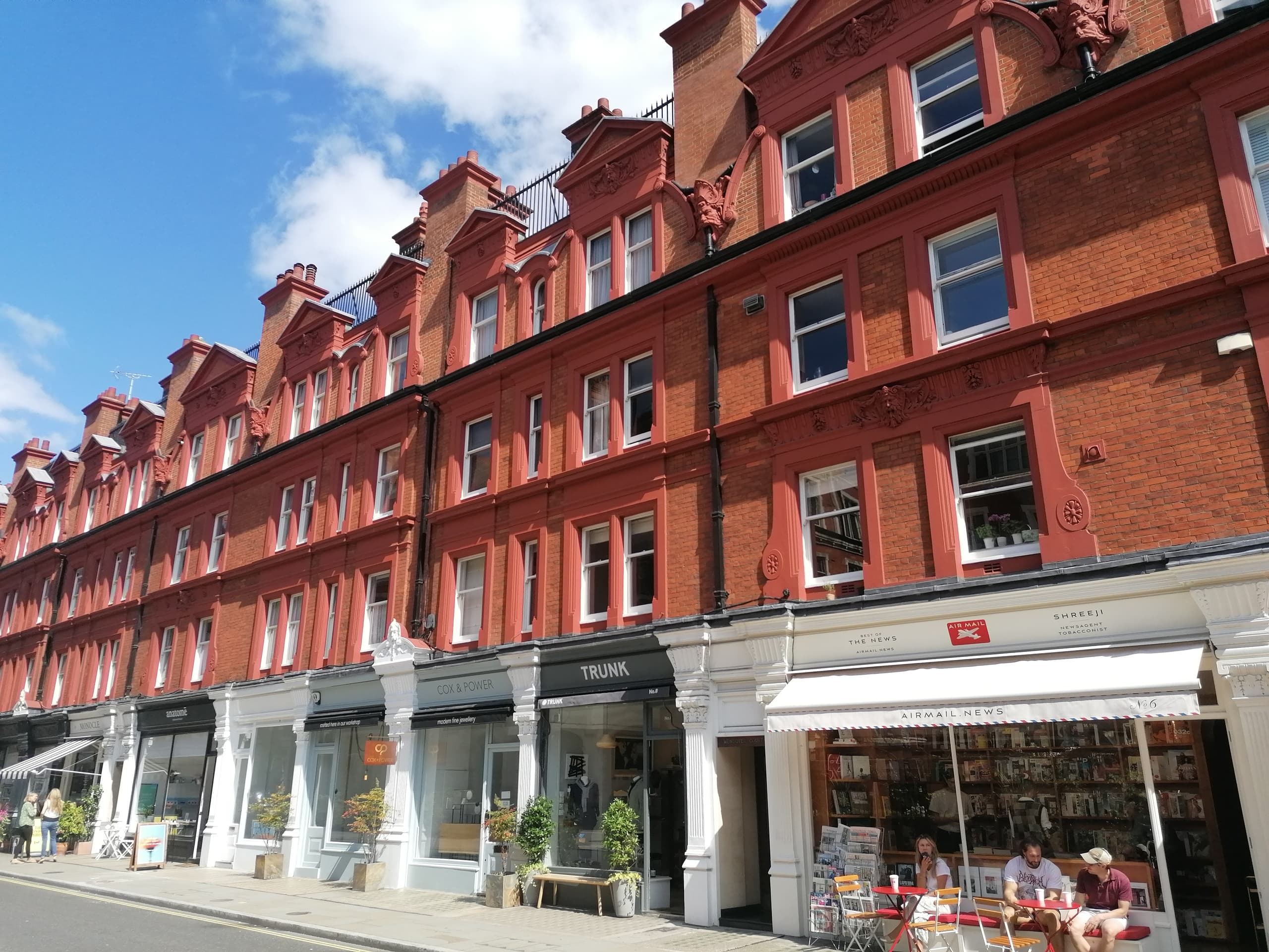 Red-brick London shopping street with storefronts and awnings, urban walk