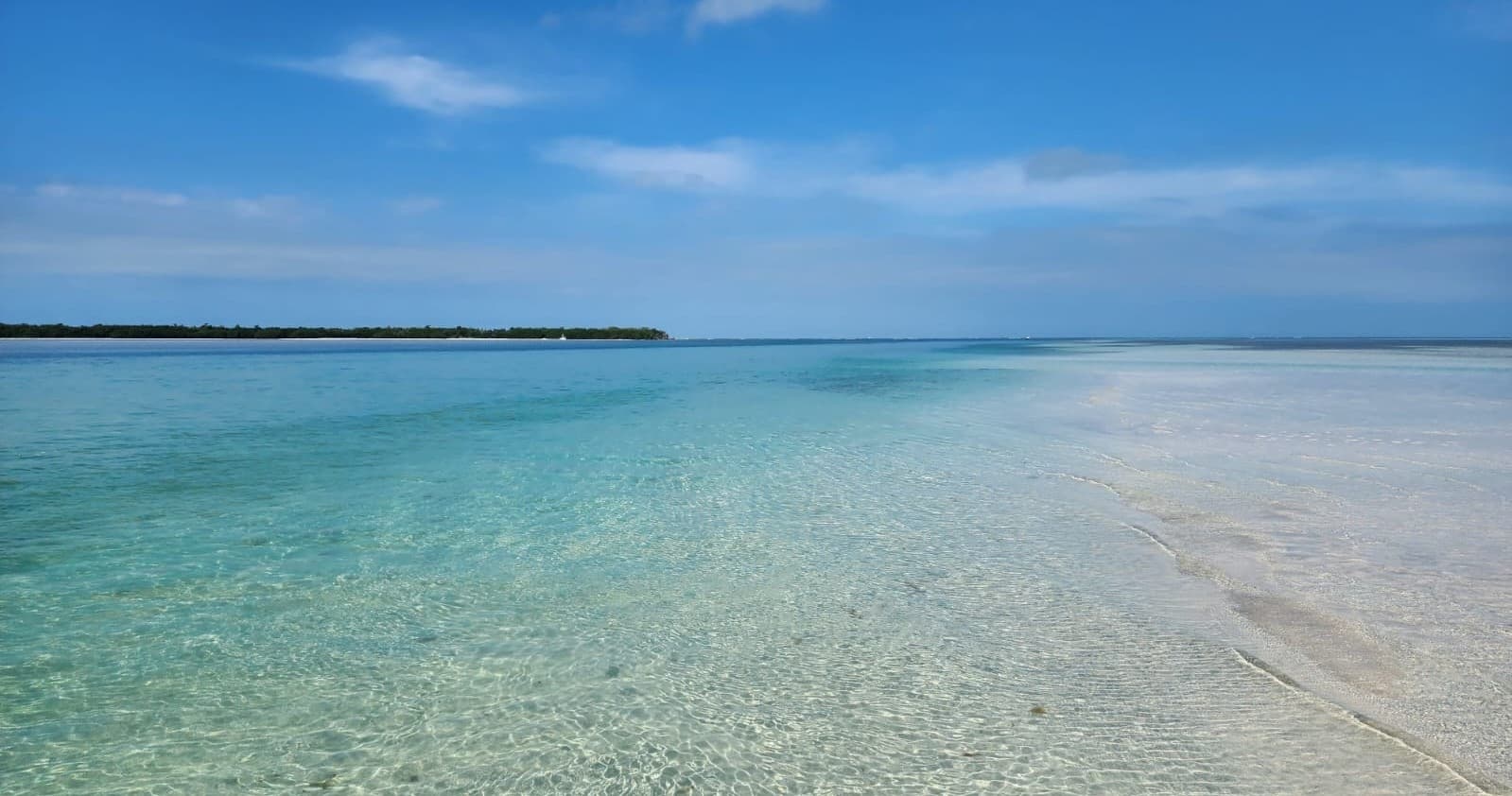 Shallow tropical lagoon with clear blue water and sand