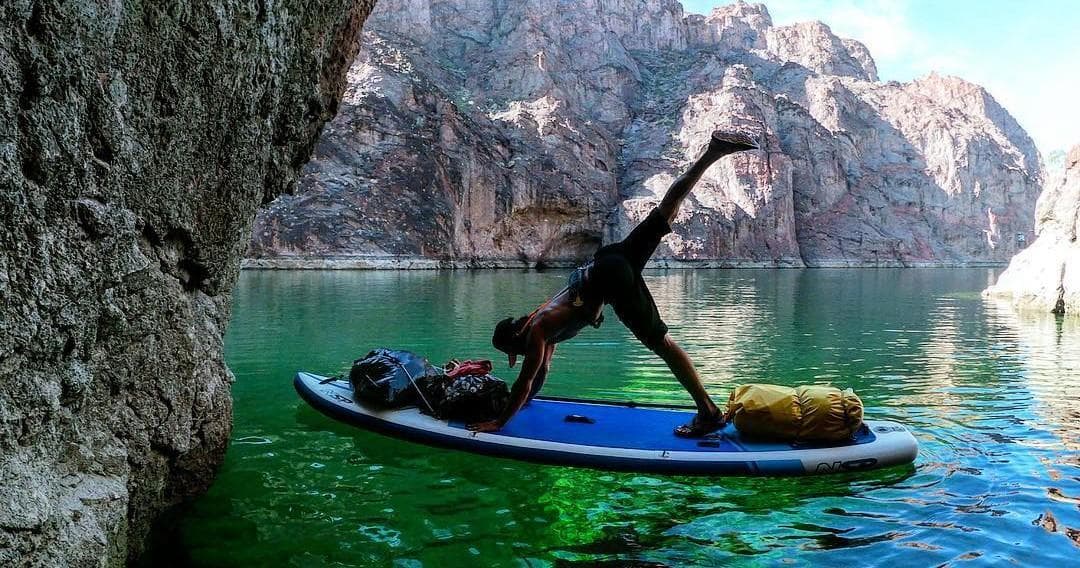 Yoga stretch on paddleboard in emerald cave lagoon