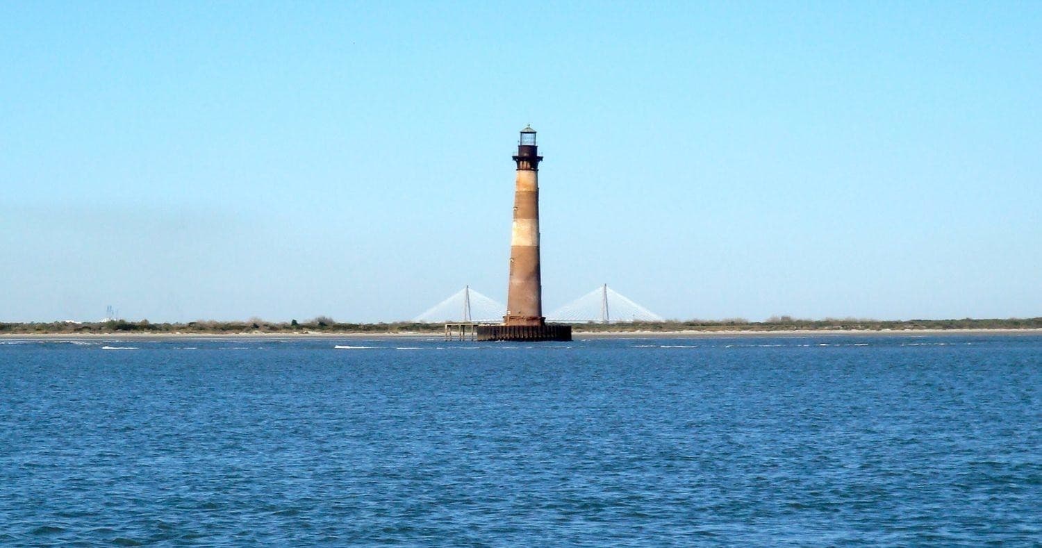 Historic lighthouse rising from coastal waters, scenic harbor