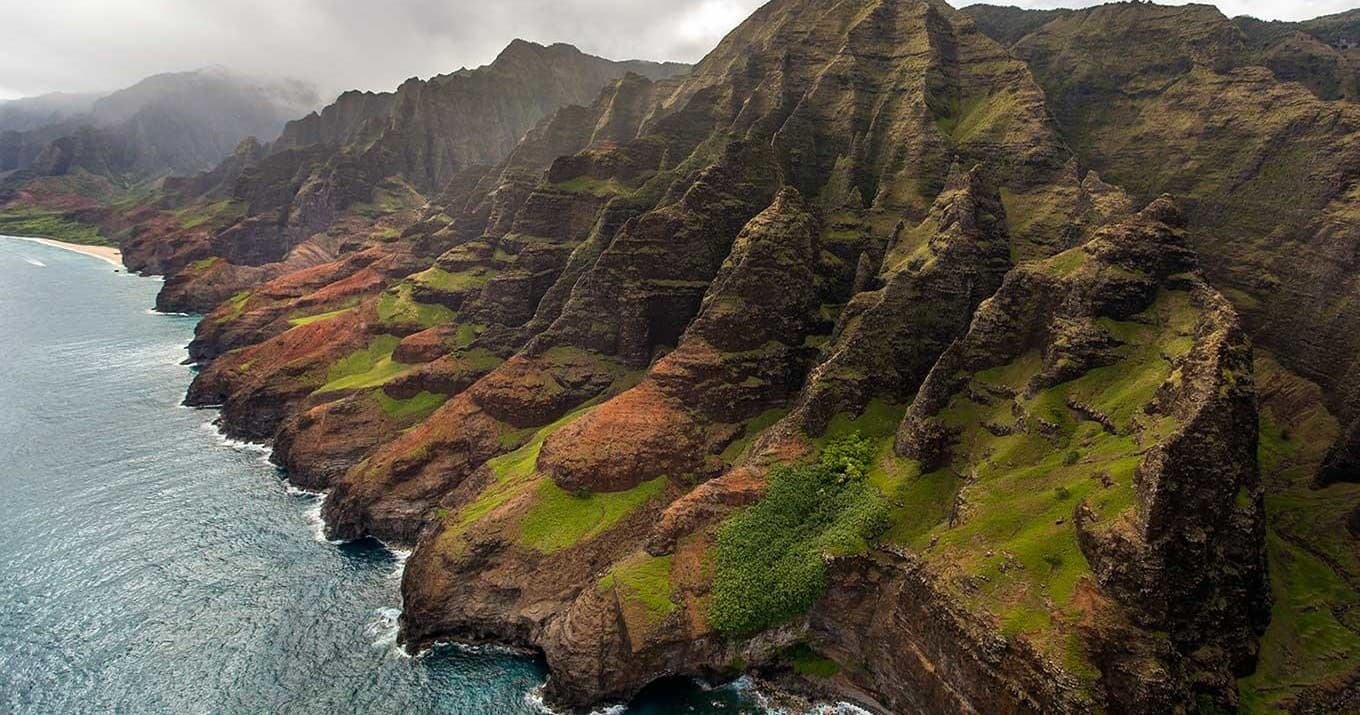 Aerial helicopter view of Na Pali Coast cliffs and ocean, Kauai