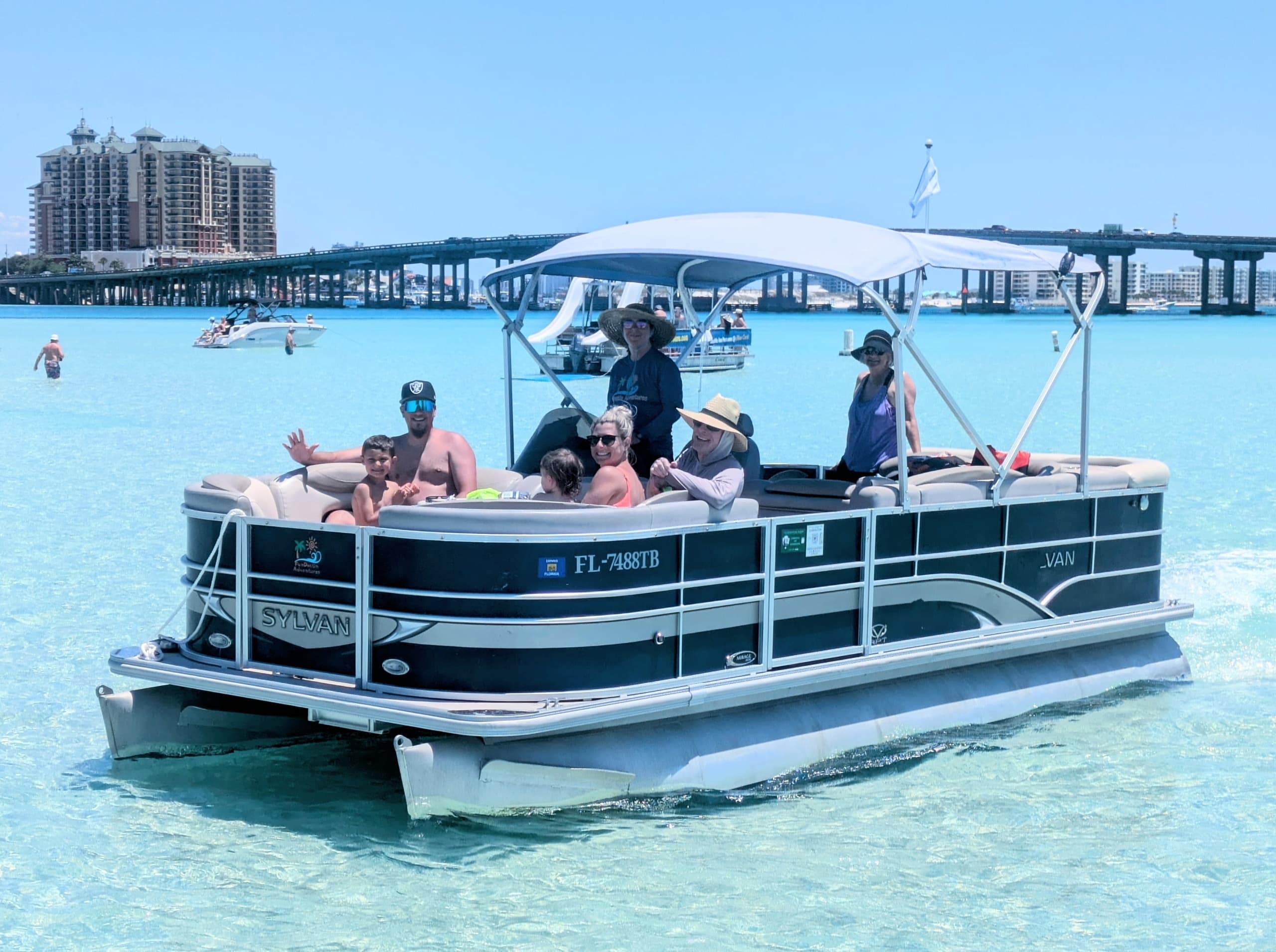 Pontoon boat cruising turquoise shallow waters near beach