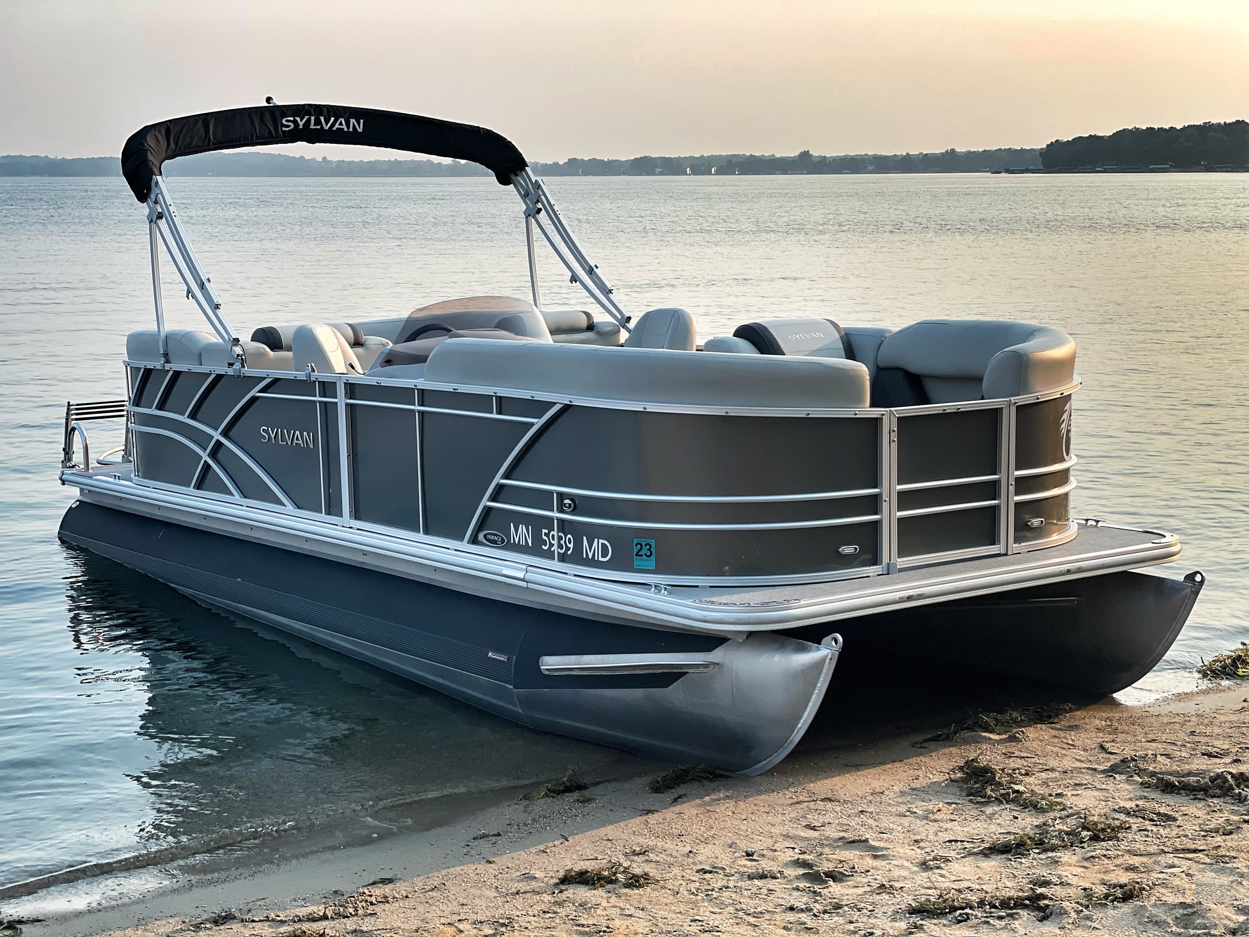 Pontoon boat beached at lakeshore ready for summer outings