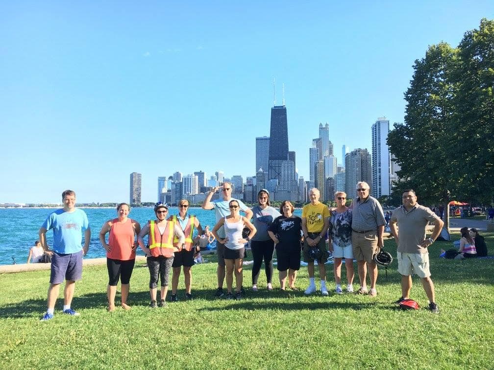 Outdoor group posing on grass with Chicago skyline and lake