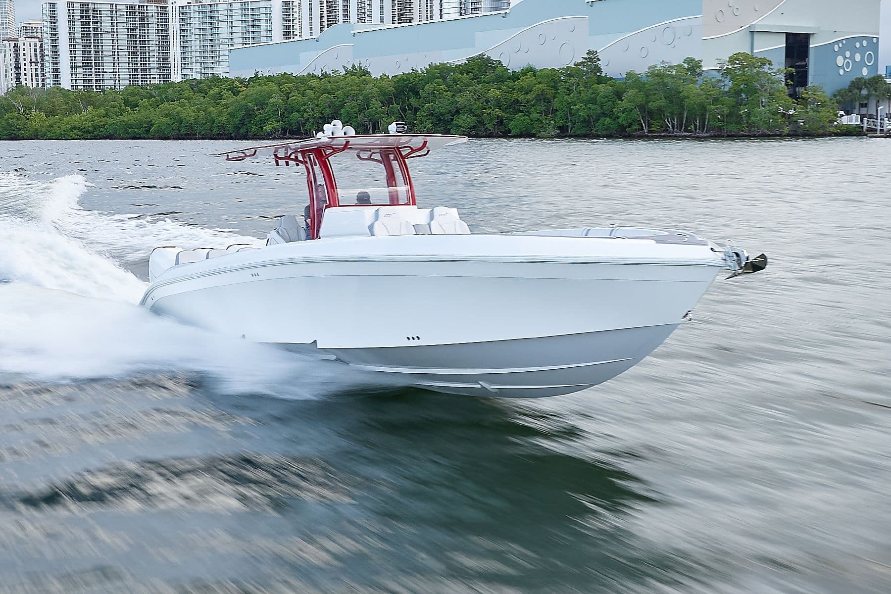 High-speed center console boat cutting through urban bay waters
