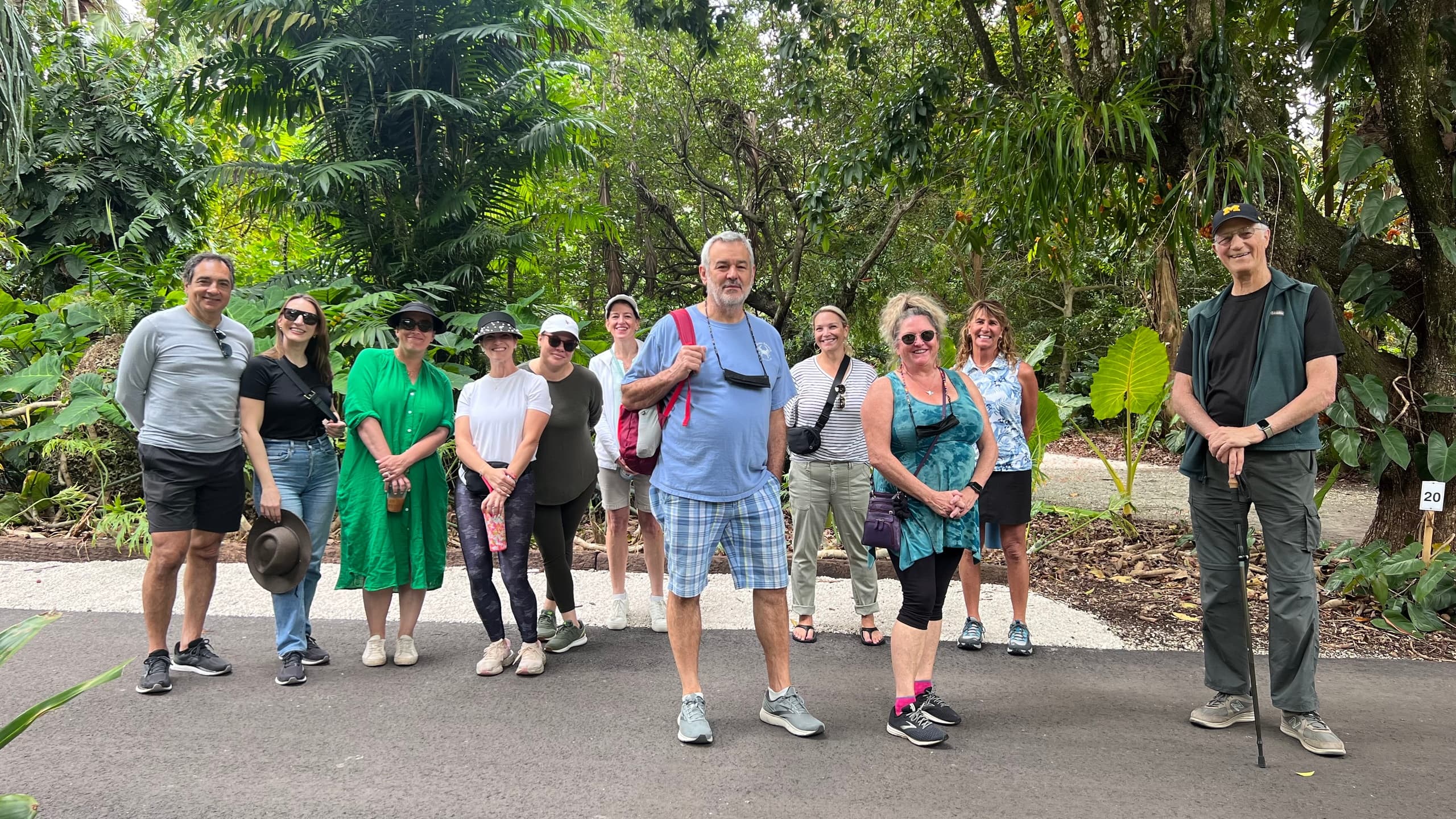 Guided walking group touring botanical garden pathway outdoors