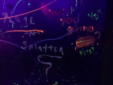 UV neon graffiti wall reading 'Will you splatter?' in studio
