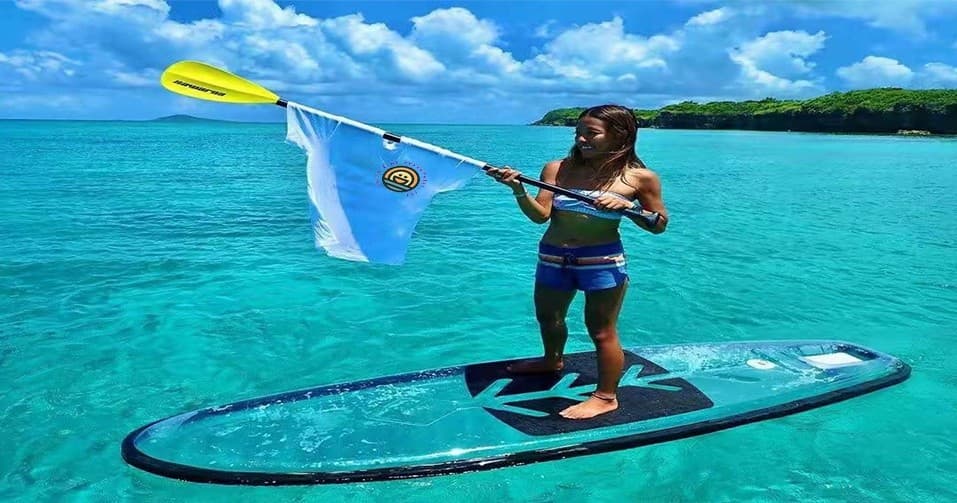 Stand-up paddleboarder cruising turquoise coastal waters