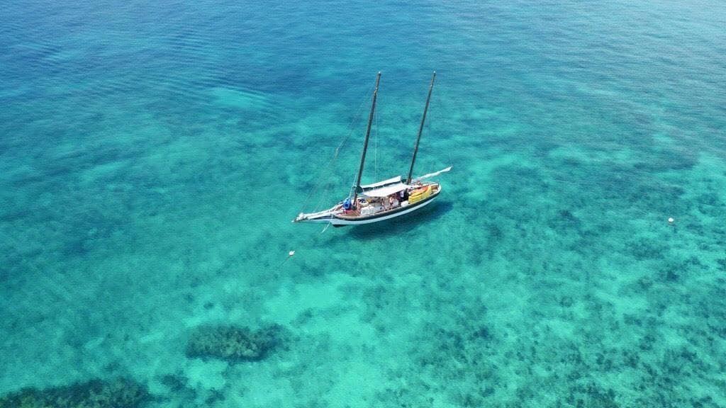 Aerial sailboat over clear turquoise reef waters in Key West