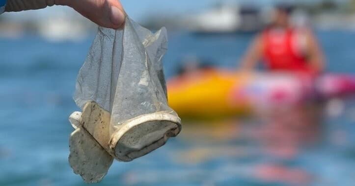 Volunteer holding plastic trash found in Sydney harbour waters