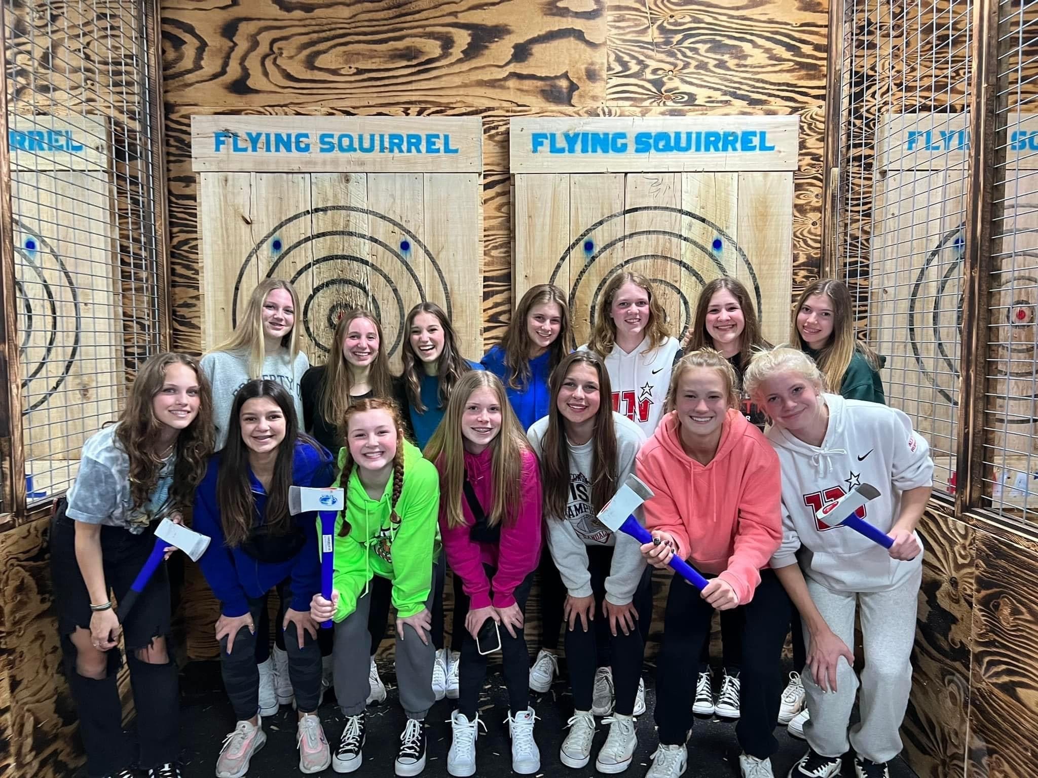 Group of friends posing after indoor axe throwing session at lane