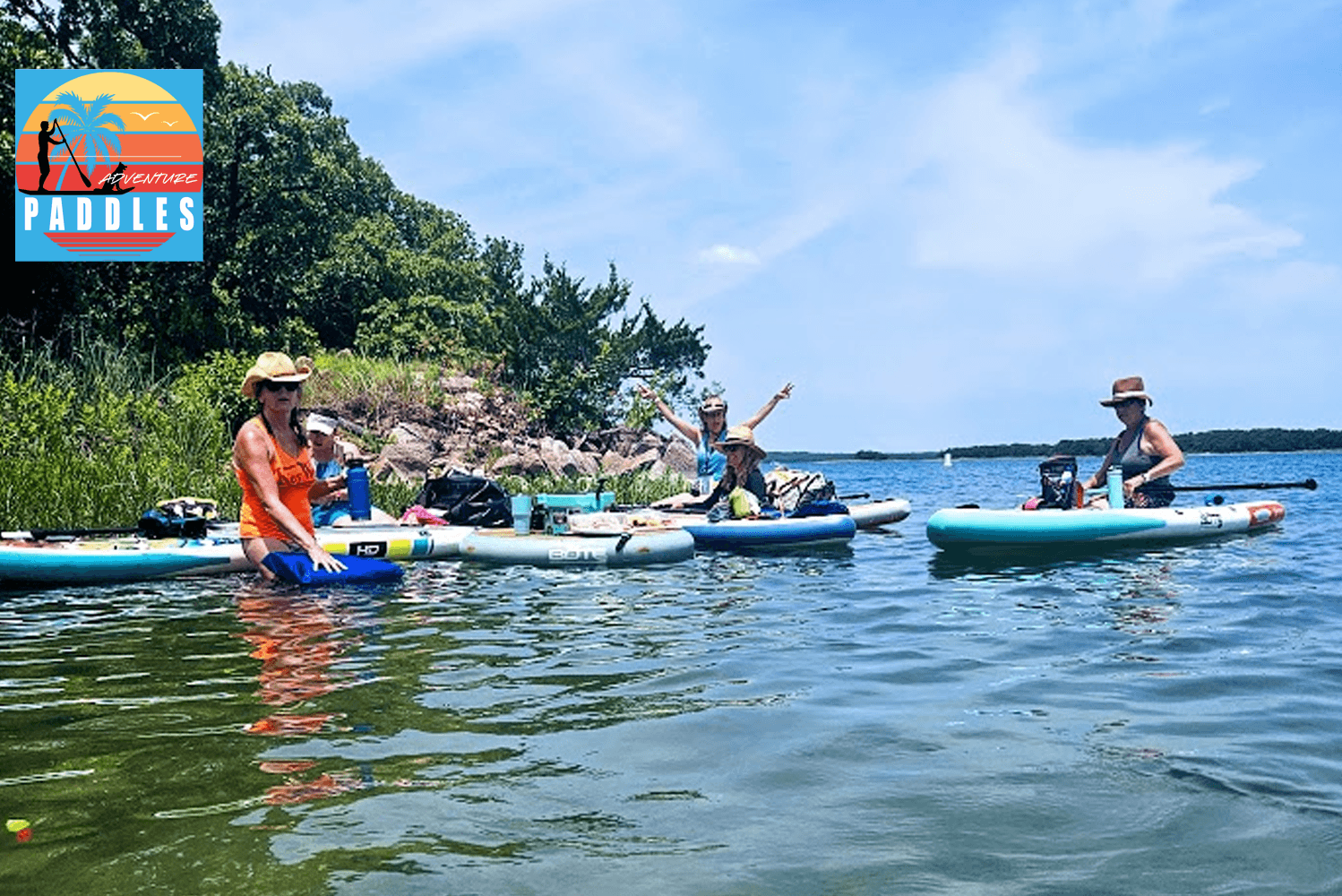 Paddleboarders and kayakers paddling on scenic blue lake
