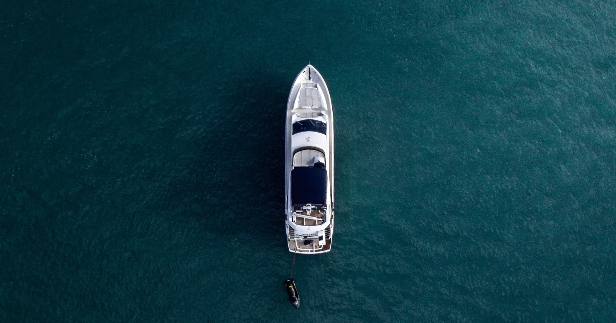 Private yacht anchored in turquoise open sea for coastal charter